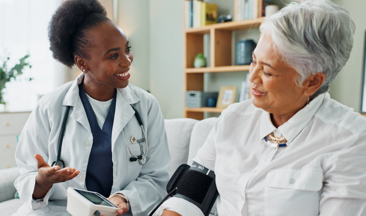 Nurse assisting client taking blood pressure reading